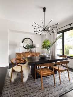 a dining room table with chairs and a clock on the wall in front of it