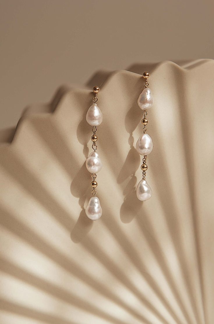 The Vega earrings feature baroque freshwater pearls suspended from gold-filled findings. Each earring is meticulously handmade by local artisans. A timeless and versatile accessory, these earrings are suitable for any occasion, from formal events to casual outings. Packaged in an elegant plastic-free reusable jewelry box, they make the perfect gift or special treat for oneself.  USA made 3mm 14k gold-filled components 6-7cm in length Baroque freshwater pearls Hypoallergenic, suitable for even th Elegant 14k Gold Filled Teardrop Earrings, Jewelry Still Life Photography, Simplistic Jewelry, Jewellery Photography Inspiration, Jewelry Product Shots, Creative Jewelry Photography, Jewelry Photos, Silk Jewelry, Jewelry Photoshoot