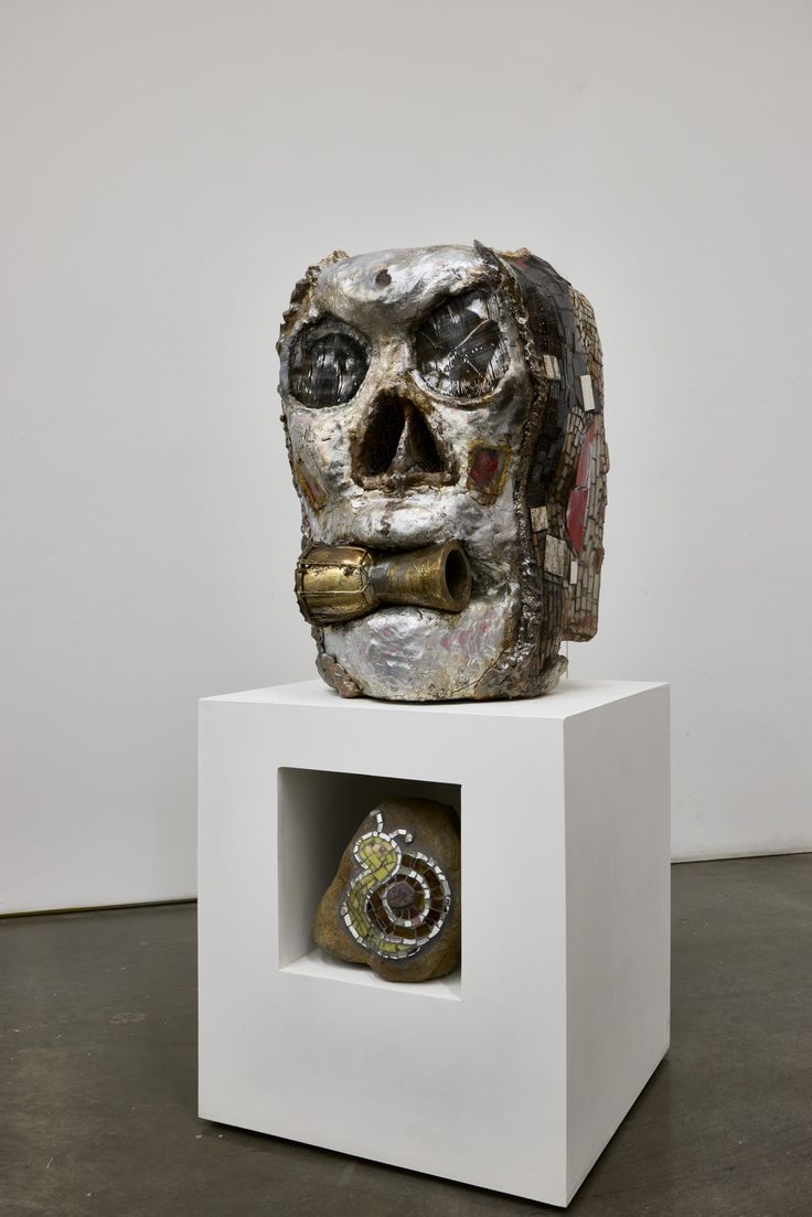 a white sculpture with a skull on it