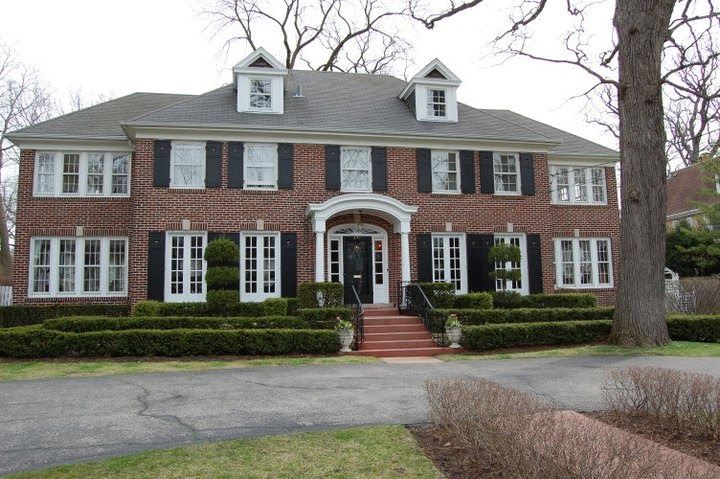 a large red brick house with black shutters and white trim on the front door