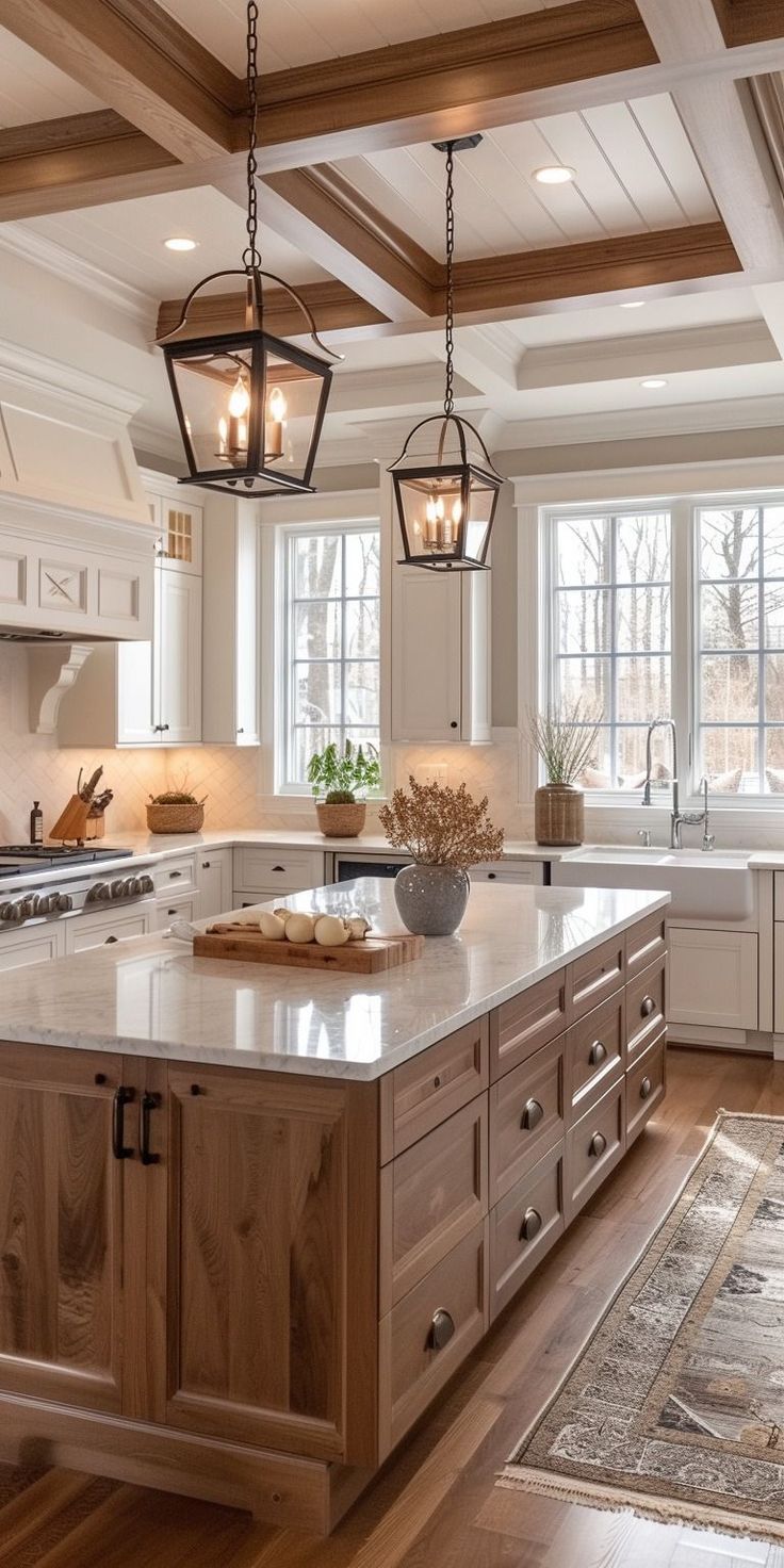 a large kitchen with an island in the middle and two hanging lights over it's windows