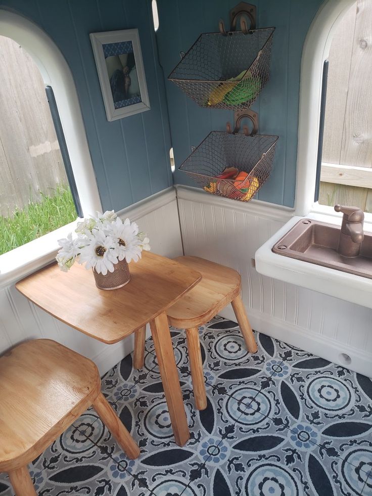 a table and two stools in a small room