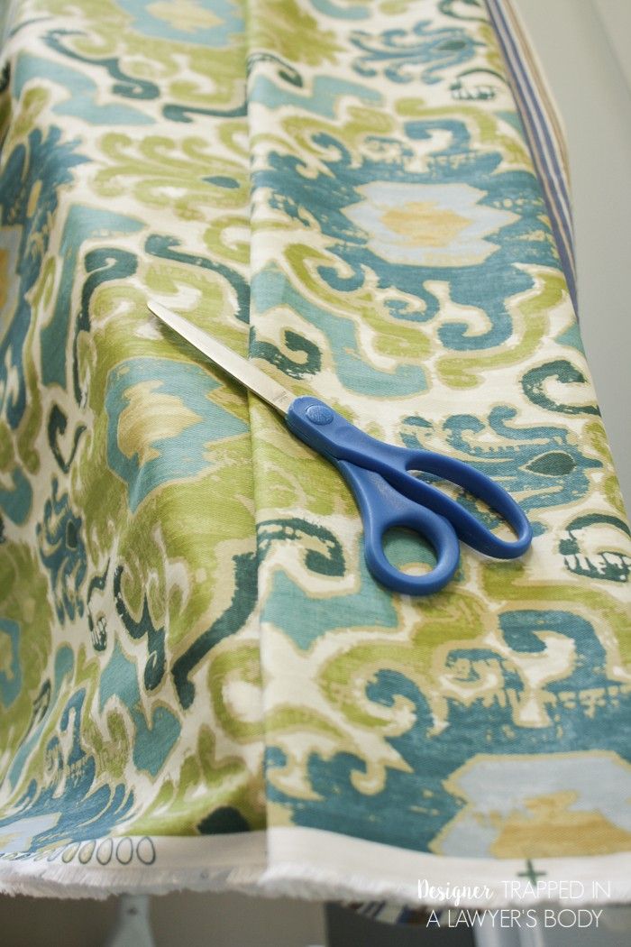 a pair of blue scissors sitting on top of a green and white fabric covered table cloth