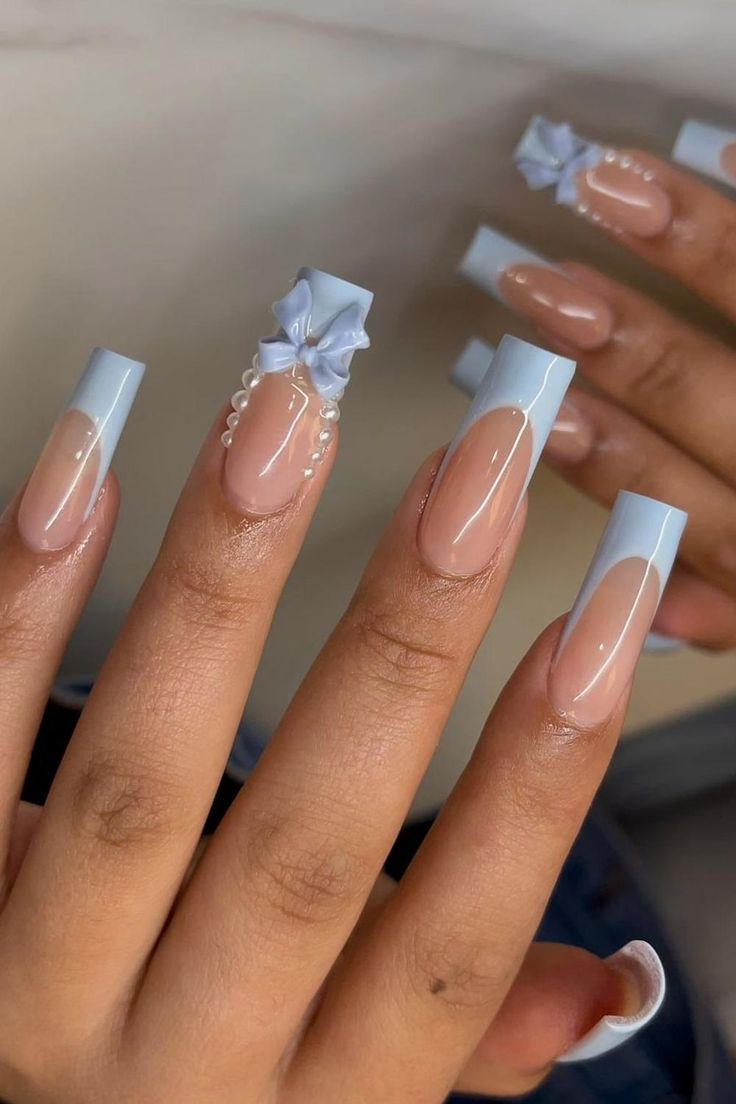 Elegant and poised, these long coffin nails feature a classy French tip in a soothing pastel blue. The highlight is a beautifully crafted 3D bow embellishment on the accent nail, complemented by a delicate string of pearls at the base, exuding a sense of sophisticated charm. A perfect blend of subtlety and eye-catching detail for a refined prom look. ✨  // Photo Credit: Instagram @nailsbyoddica French Tips Acrylic With Design, Acrylic Nails Coffin Blue, Nails Ideas Charms, Cute French Tips Nails, Nails Ideas With Charms, Cute Nail Designs Charms, Cute Simple Quince Nails, Square Nails Long Design, Nails Light Blue And White