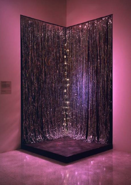 a room that has some kind of curtain on the wall with lights in it,