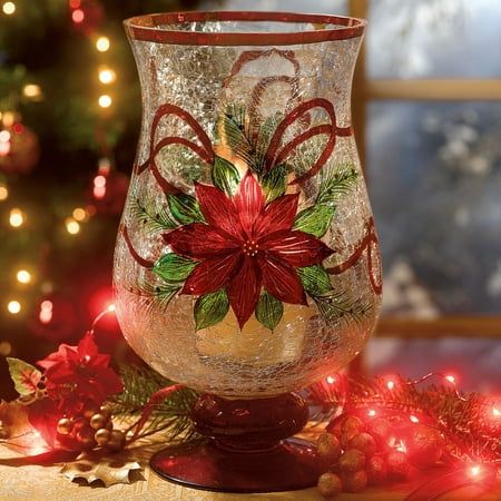 a glass vase sitting on top of a table next to a christmas tree with lights