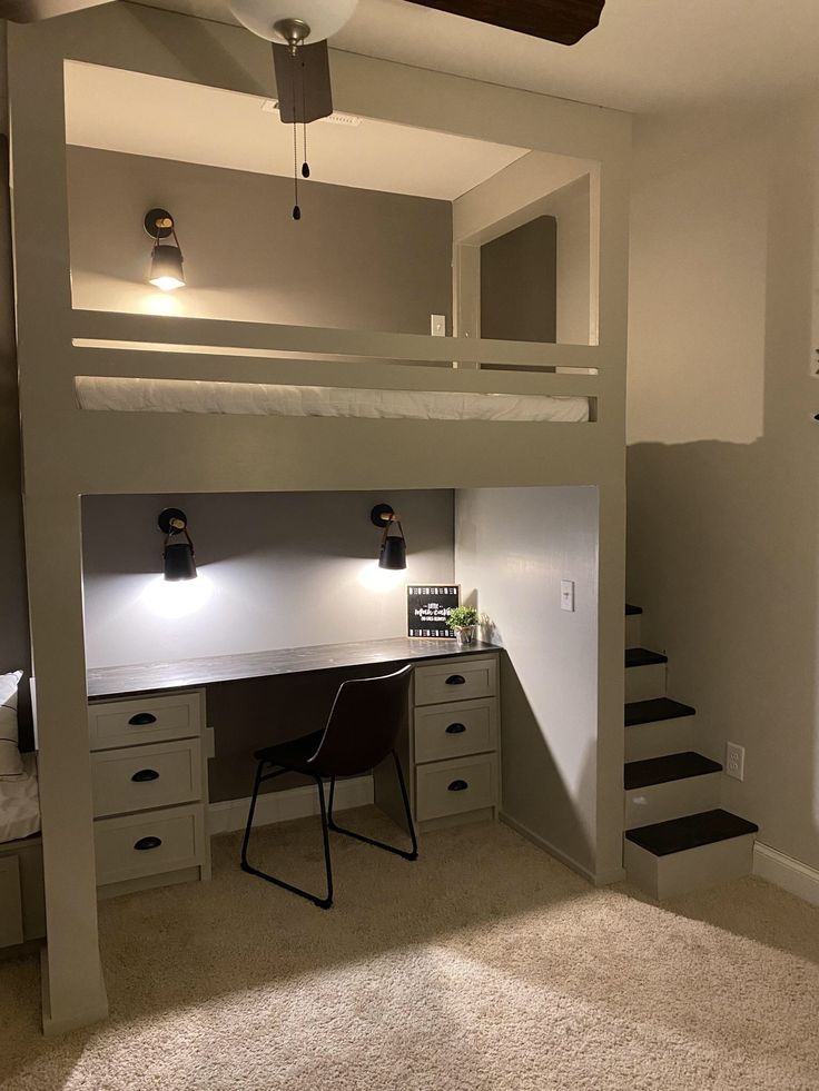 a loft bed with desk underneath it and stairs leading up to the upper floor area