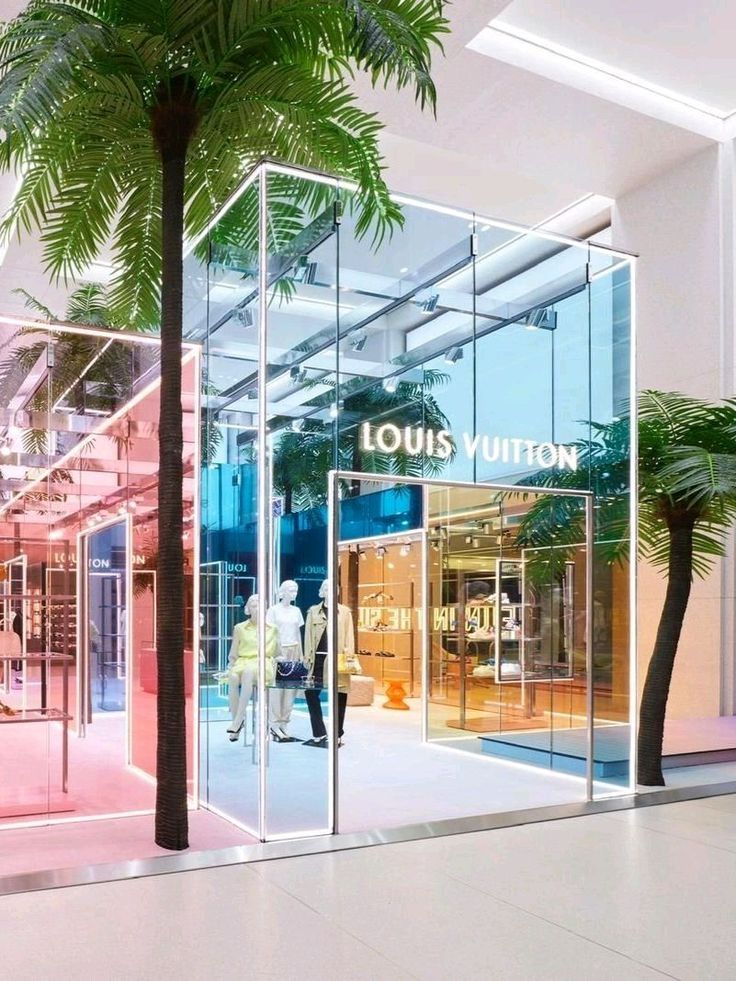 the entrance to louis vuitton store with palm trees