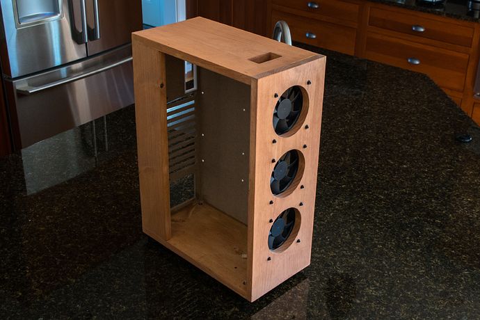 a wooden box with holes in it sitting on a counter top next to a dishwasher