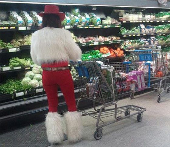 a person in an animal costume pushing a shopping cart through a grocery store aisle with vegetables