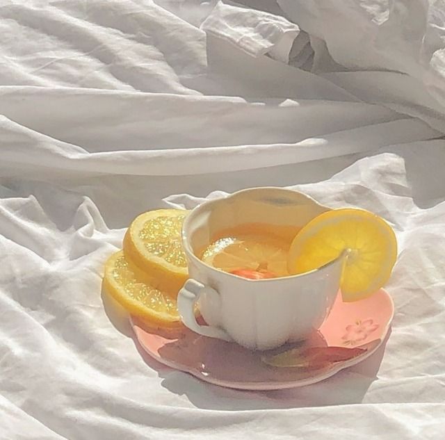 a cup of tea with lemon slices on the saucer