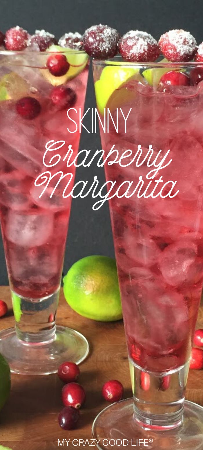 two glasses filled with cranberry margarita on top of a wooden table