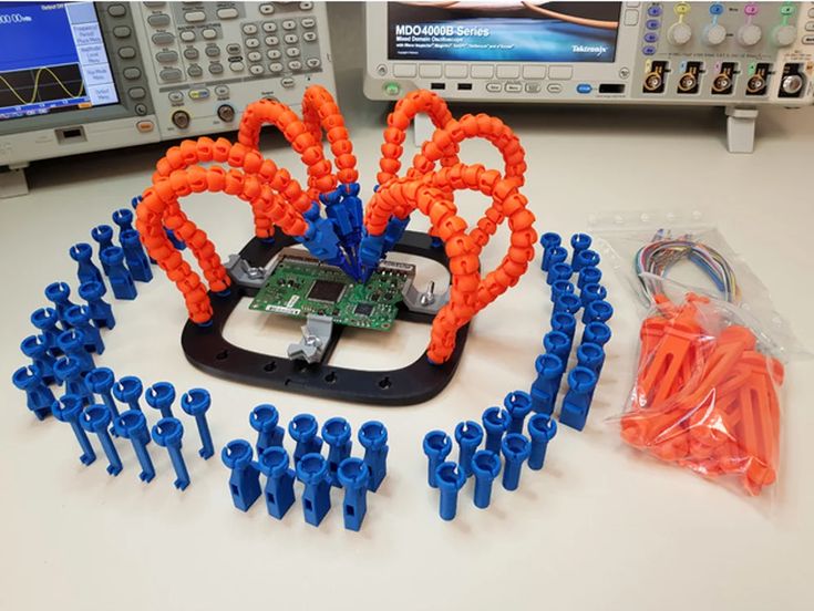 a group of blue and orange plastic figures sitting on top of a table next to a computer monitor