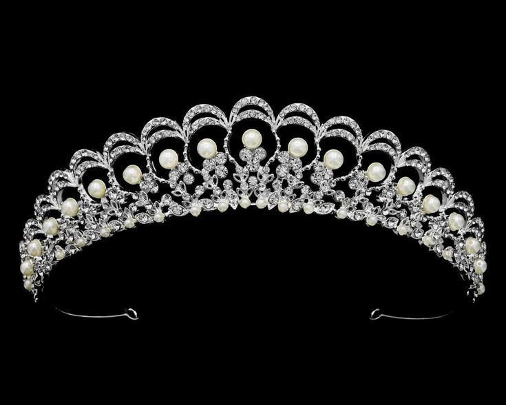 Pearl and Rhinestone Wedding Tiara This beautiful tiara will provide classic elegance to your bridal ensemble. The silver plated design is adorned with lustrous pearls and sparkling crystal rhinestones. This headpiece will be a memorable addition to your modern wedding look! Size: 1 1/4" High at its peak. Color: Silver/Light ivory. Style: T56300. Please allow about a week for delivery. Shipping Policy. Return Policy. Pearl Tiara, Bride Tiara, Beautiful Tiaras, Regal Design, Headpiece Jewelry, Rhinestone Tiara, Wedding Look, Light Ivory, Crystal Crown