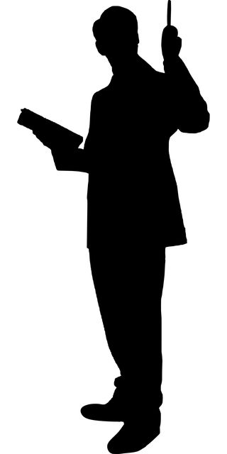 the silhouette of a man holding an umbrella in one hand and reading a book in the other