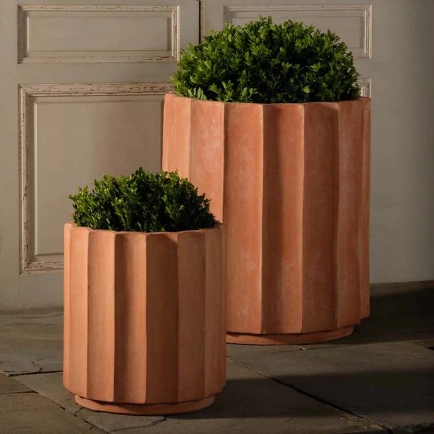 two planters sitting next to each other in front of a door