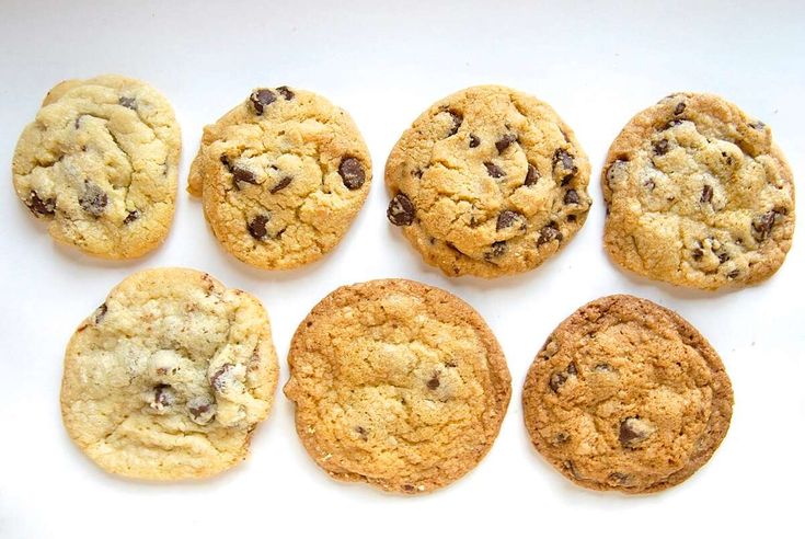 nine chocolate chip cookies on a white surface