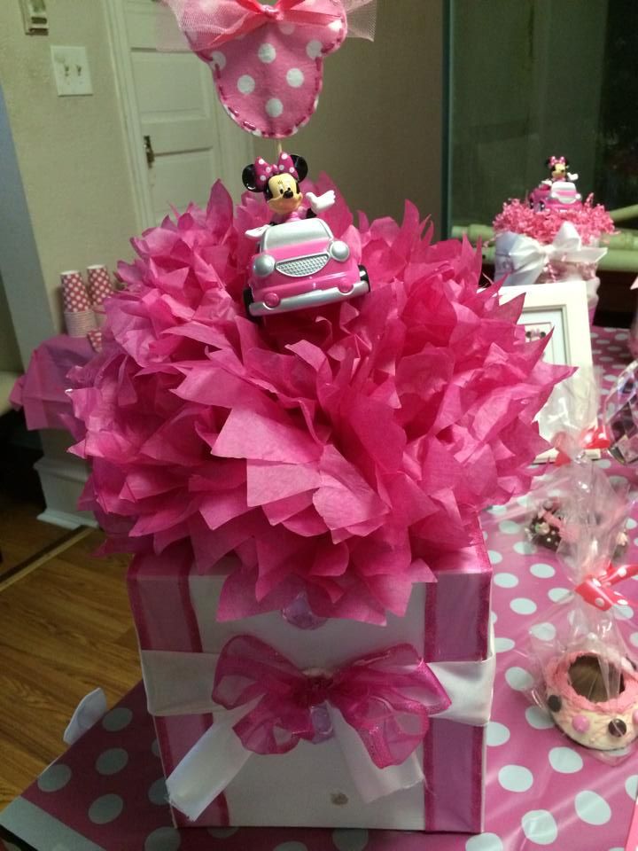 a pink and white gift box with minnie mouse decorations on it's top sitting on a table