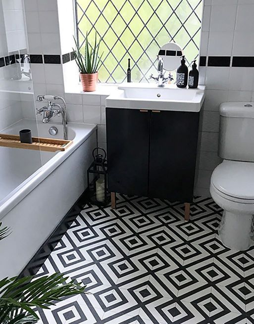 a bathroom with black and white tile flooring next to a bathtub, toilet and sink