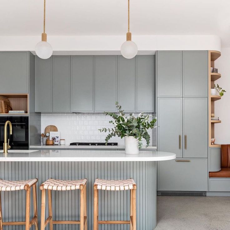 two stools are in front of the kitchen island and countertop, which is painted gray