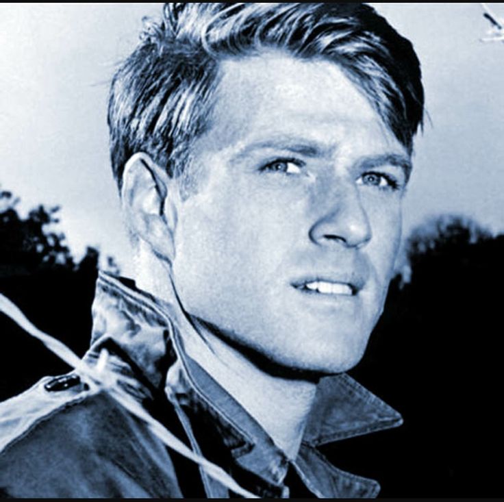 a black and white photo of a man in leather jacket looking off into the distance