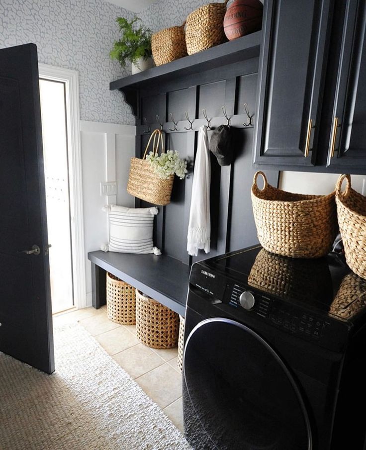 a washer and dryer in a small room with baskets on the shelves above