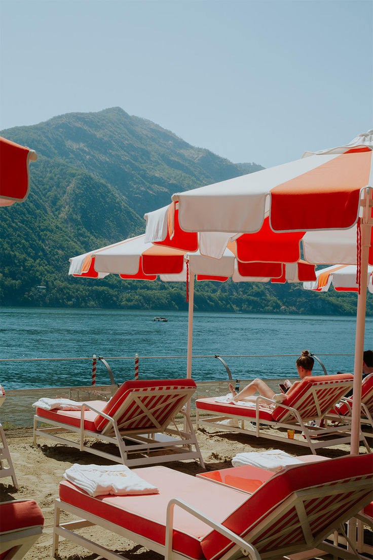 lounge chairs and umbrellas are lined up on the beach