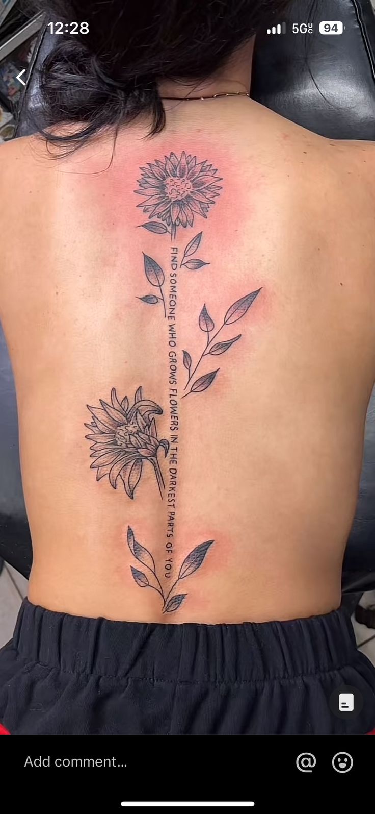 the back of a woman's body with a flower tattoo on her lower back