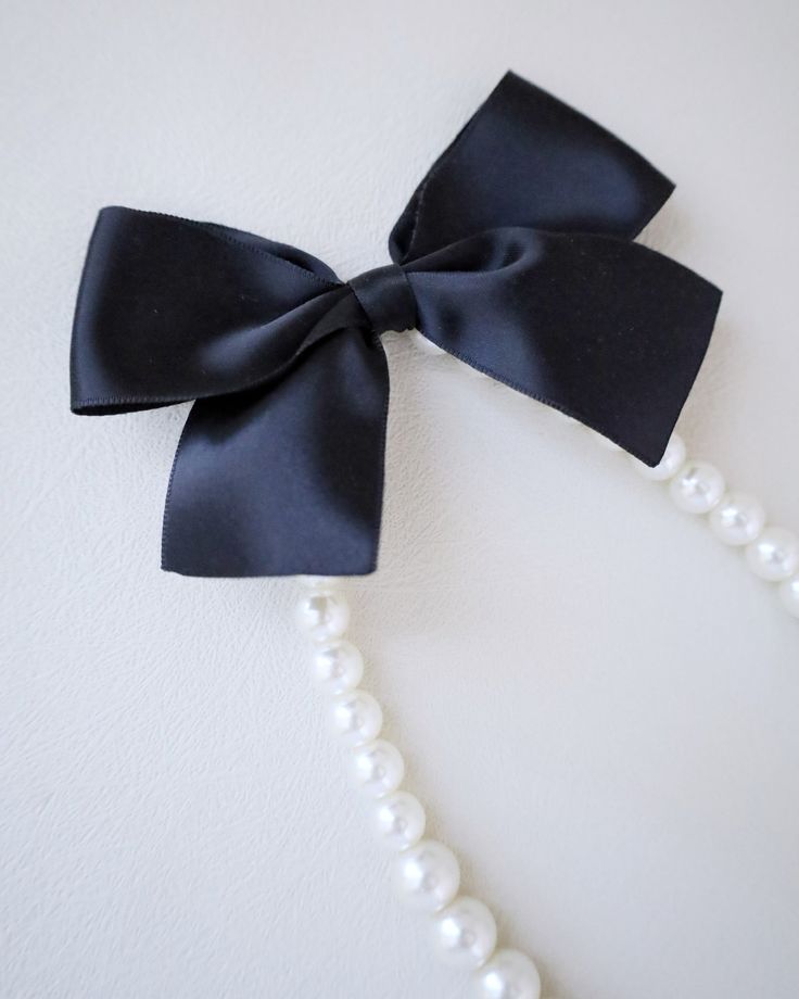 A classic pearl necklace with a dainty satin bow definitely to add an effortless romantic and classic look to your formal or casual style. Perfect to complete your date night, wedding, bridesmaids, holiday party, and any special occasions. This necklace is elastic and consists of assorted sizes of pearls. The bow can be styled sideways or at the back, or turn it around for another way to wear it. DETAILS: HANDMADEIMPORTED MATERIALS Pearl Bow Necklace, Classic Pearl Necklace, Pearl Bow, Night Wedding, Bow Necklace, Satin Bow, Sheet Of Paper, Wedding Bridesmaids, Holiday Party