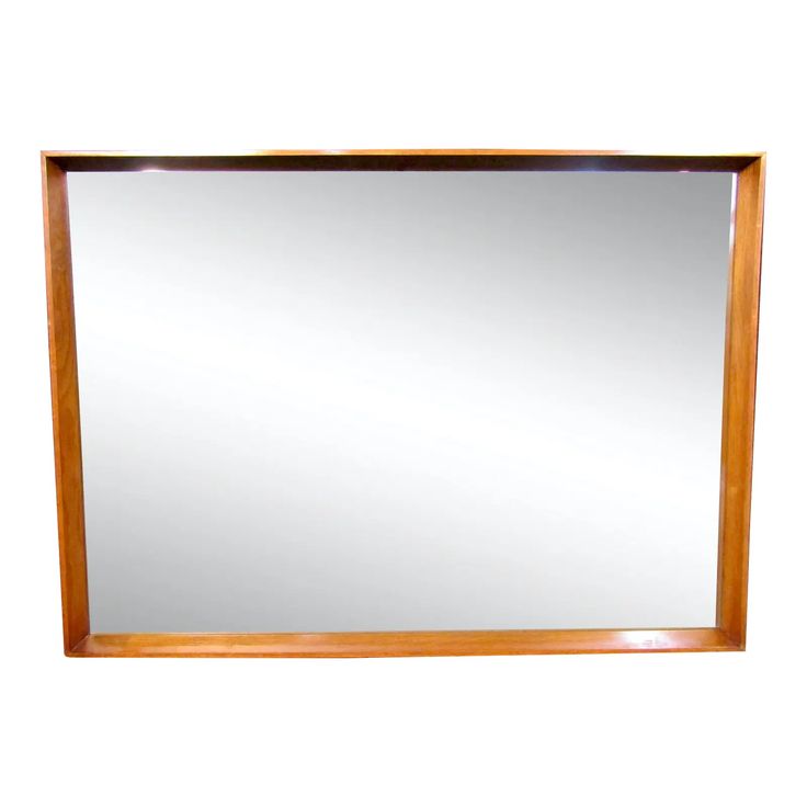 a wooden framed mirror on a white wall