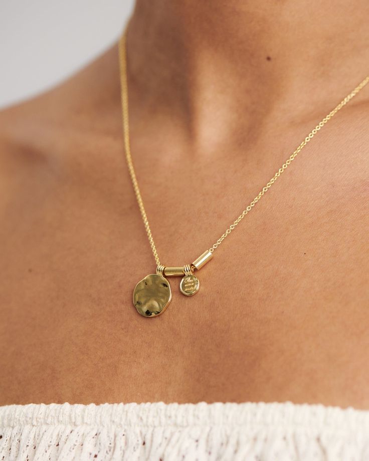 Two unique pendants and gold links dangle from a delicate chain, bringing you a personal love letter from our founder, "Love and Kindness are never wasted". So much more than just a mantra let our Nyon necklace become your talisman & daily reminder to act with care, for others, for the planet & for yourself. Add a touch of classic beauty & pair your Nyon necklace with our Merida earrings. 
Details

Handcrafted in a thick layer of 18k gold on sterling silverAdjustable chain length: 50 cm + 5 cm e Personalized Amulet Necklaces For Anniversary, Personalized Amulet Necklace For Anniversary, Elegant Hammered Medallion Necklace As Gift, Elegant Hammered Medallion Necklace Gift, Dainty Engraved Brass Charm Necklaces, Amulet Style Engraved Necklace For Anniversary, Engraved Amulet Necklace For Anniversary, Hammered Yellow Gold Medallion Necklace As A Gift, Hammered Yellow Gold Medallion Necklace Gift