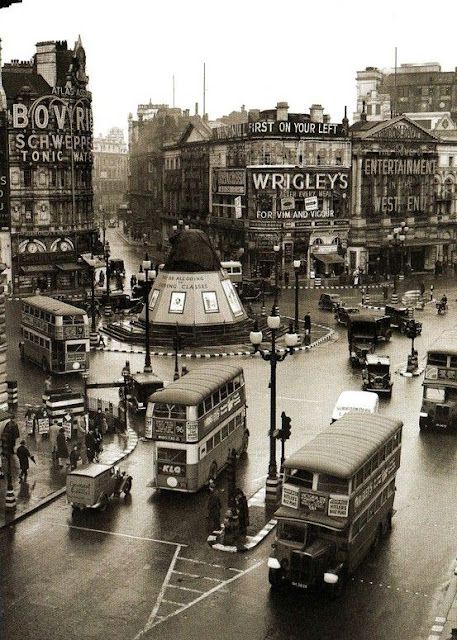 an old black and white photo of buses in the street