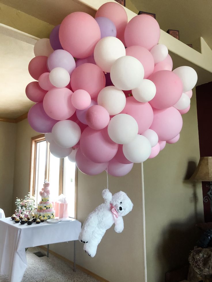 a bunch of balloons that are in the shape of a teddy bear hanging from a ceiling