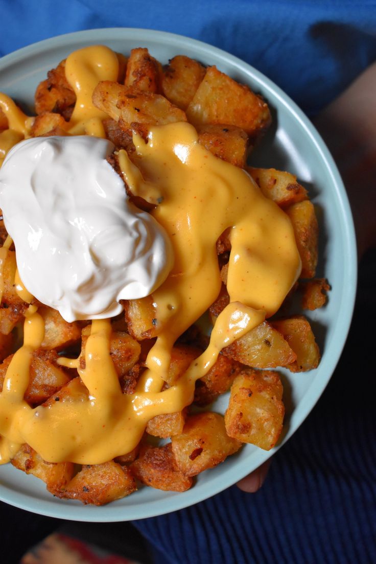 a bowl filled with tater tots covered in cheese