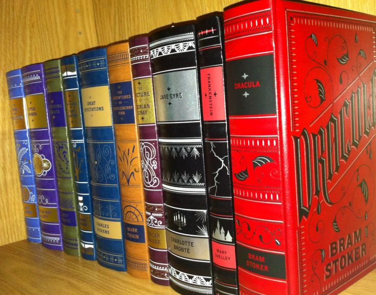 a row of books sitting on top of a wooden shelf