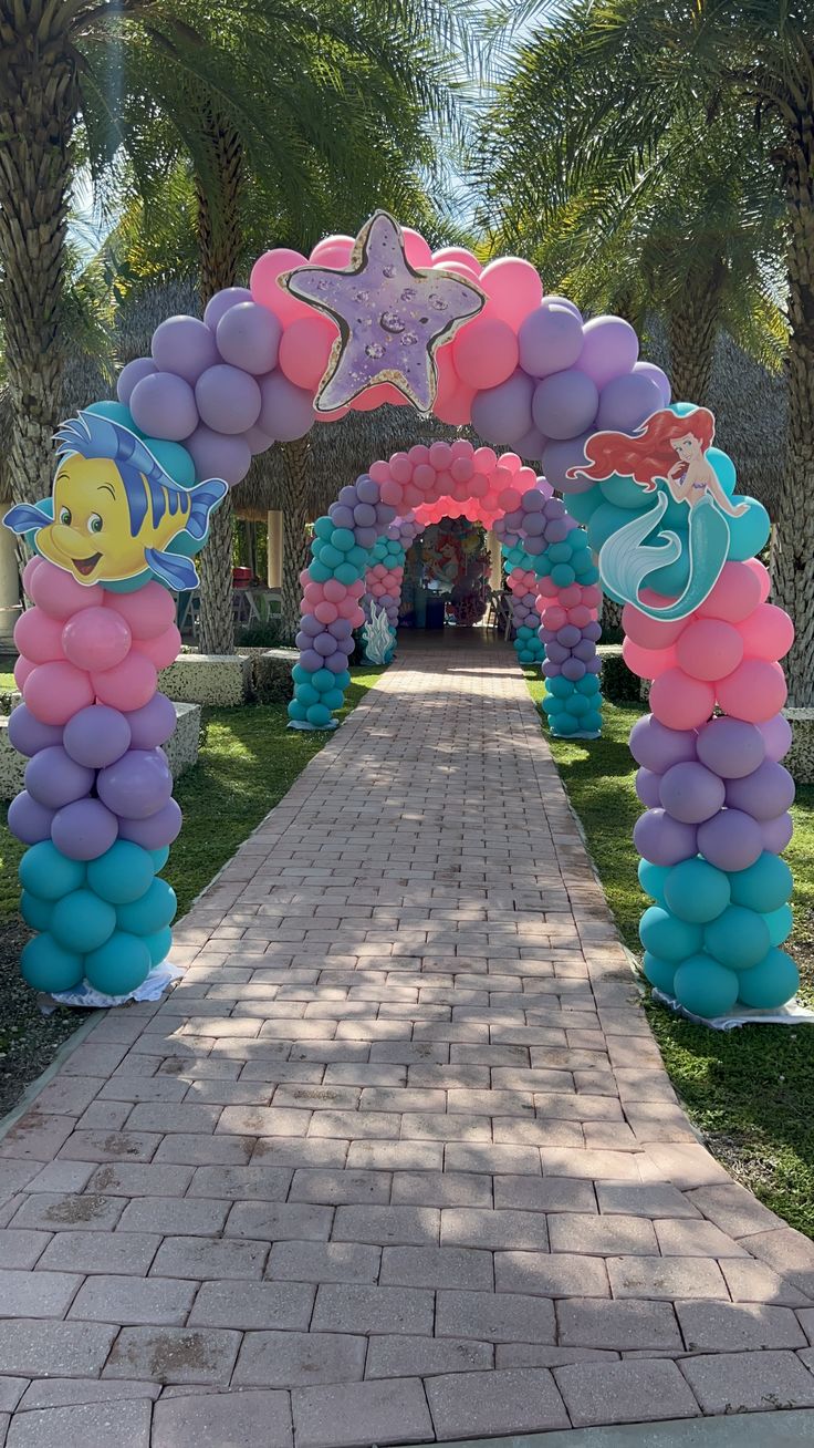 an arch made out of balloons with little mermaids on it