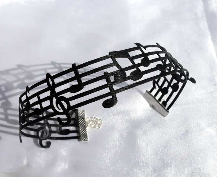 A polyester ribbon blend Black Music Note Choker, Music Symbol Choker, Black Music Themed Necklace, Black  Musical Note Choker, Sheet Music Treble Clef Choker. Ribbon has musical notes design (mixture of notes) and silver plated ends. Choker width is 2 cm.  Choker has a silver plated lobster clasp fastening with 5 cm extender chain.  Please select your size using the drop down menu. Sizes are below and include the length of the extender chain:  25 - 30 cm in length (12 inches) 30 - 35 cm in length (14 Inches) 35 - 40 cm in length (16 inches) 40 - 45 cm in length (18 inches) Can be made to alternative lengths, please just message me.  Please see photos for details.  This is costume jewellery and will need to be treated with care.   Posted by recorded delivery.  Thank you for looking. **10%