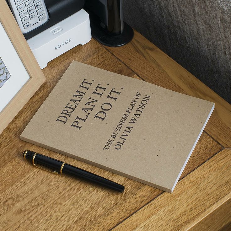 a book sitting on top of a wooden table next to a pen