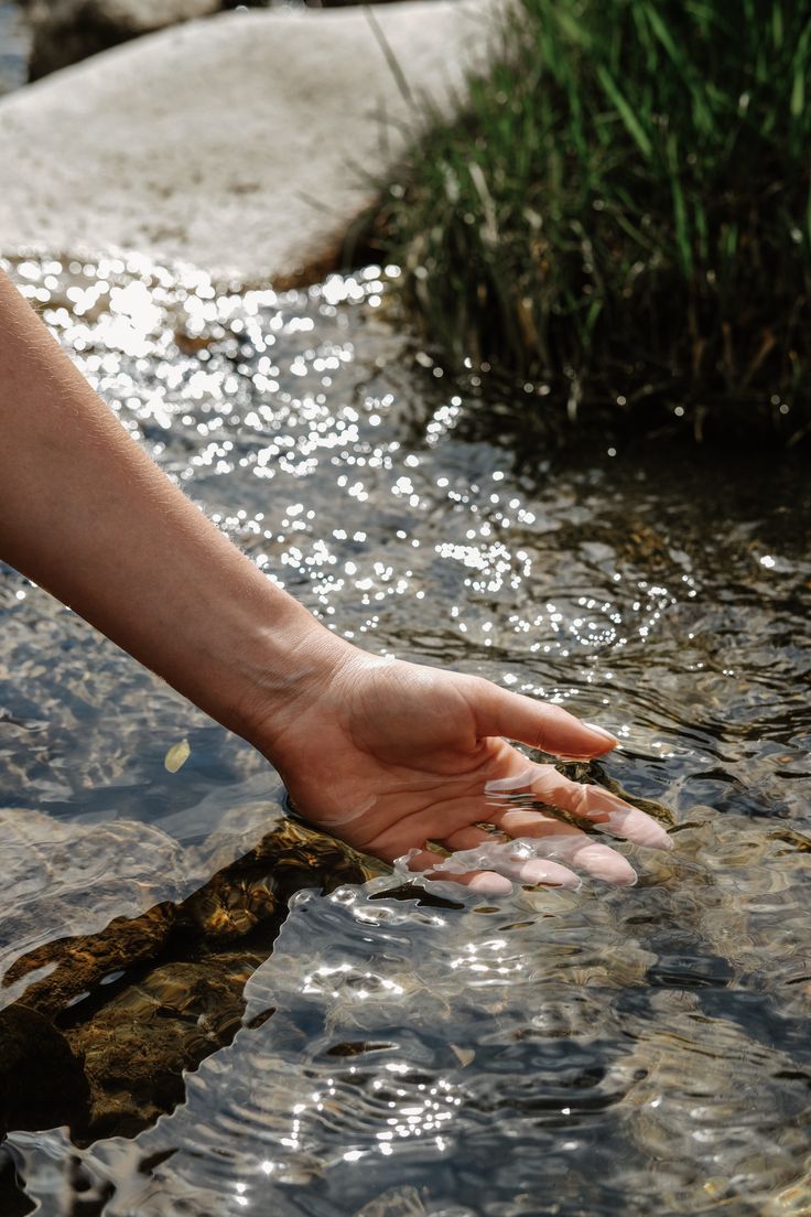 a person reaching for something in the water with their hand on it's side