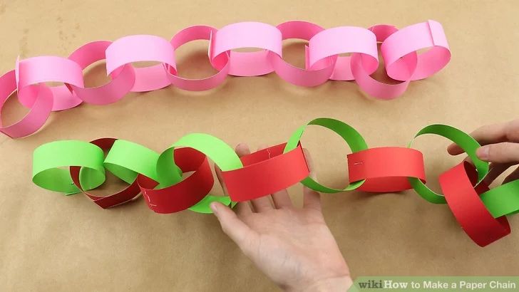 someone is making paper chains out of colored paper