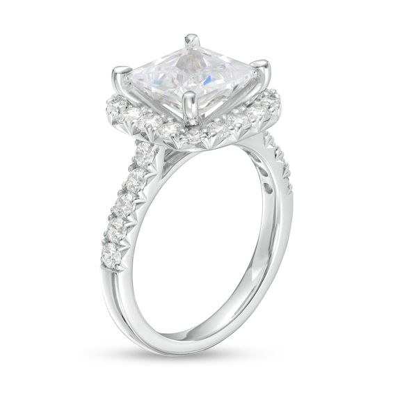 a princess cut engagement ring with two side stones on the band and an accent diamond in the center