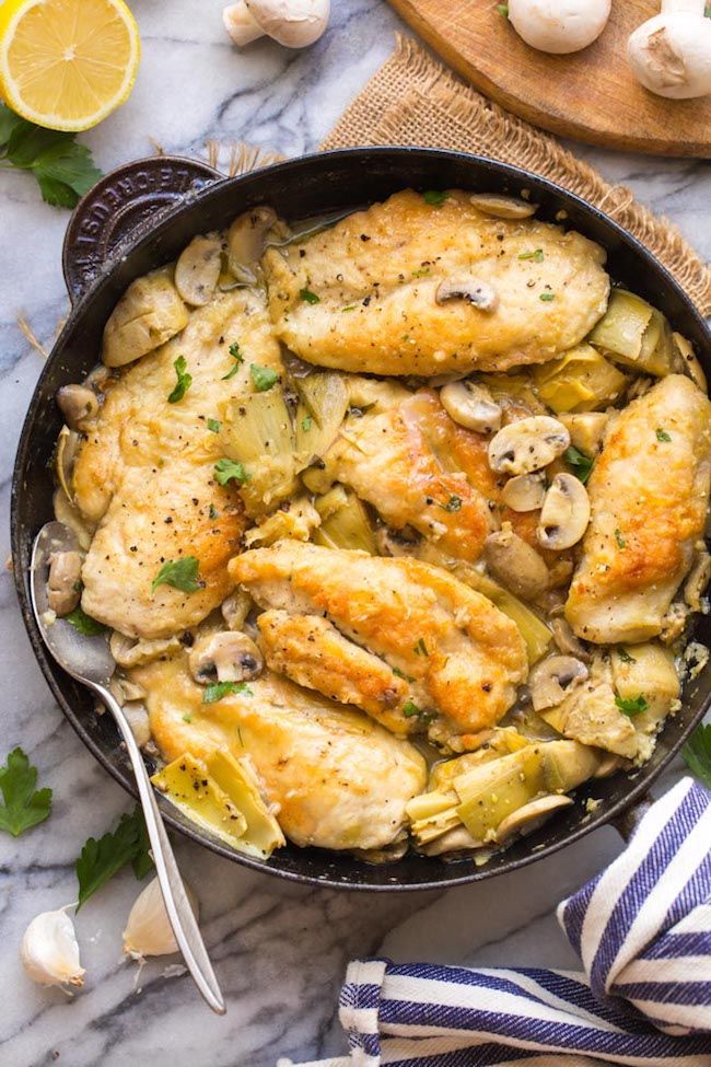 mushroom and artichoke chicken in a cast iron skillet