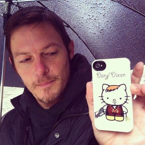 a man holding an umbrella with a hello kitty phone case on it's side