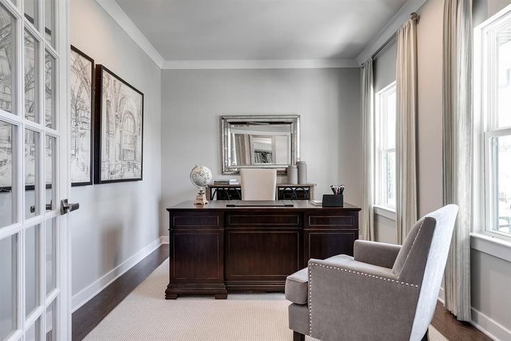 a chair sitting in front of a desk with a mirror on it's wall