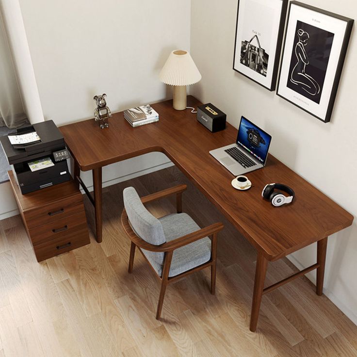 a wooden desk with a laptop computer on top of it next to a chair and lamp