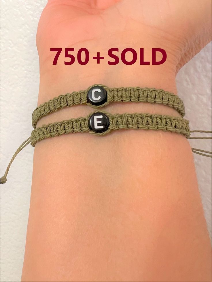 two bracelets with letters are shown on the wrist