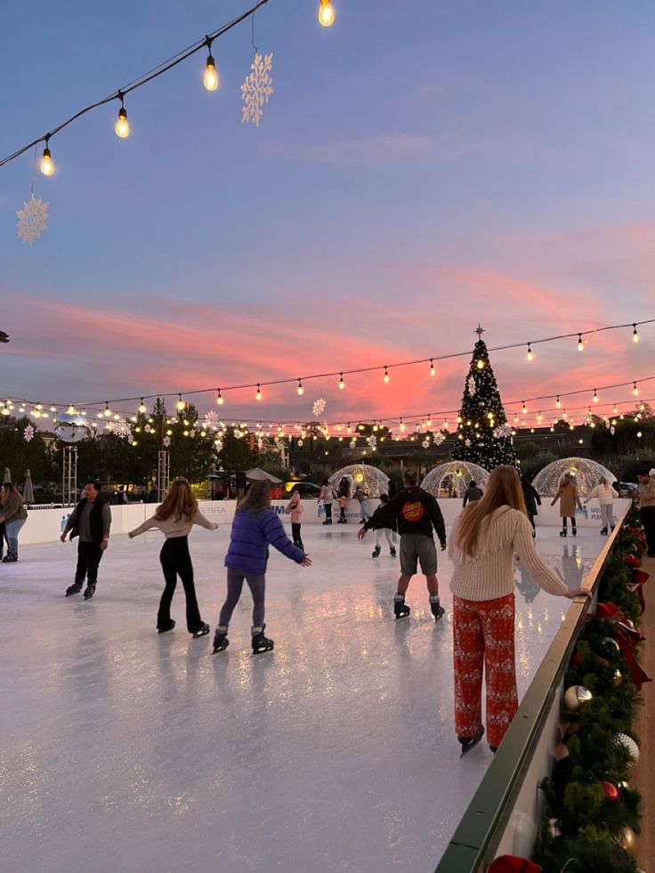 people skating on an ice rink at dusk