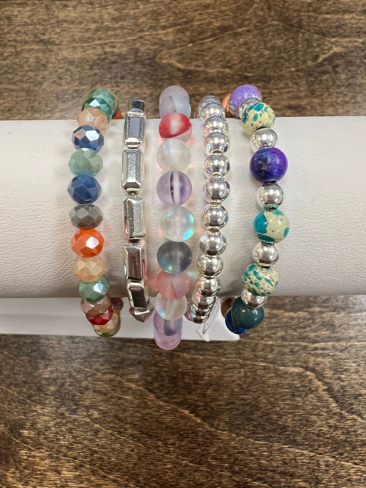 Add a sparkle to your style with Abby's Silver Colour Bracelet Stack! This gorgeous stack of bracelets feature a rainbow of beautiful colors, making it the perfect accessory for any outfit! It's sure to bring a pop of colour to your day! *please note: these bracelets are handmade and the beads vary in colors and shades. You will not receive the exact bracelets that are shown. If you are a HOC client, you can message us with your season and we will do our best to make your bracelet with at least Multicolor Wrap Bracelet As A Gift, Multicolor Wrap Bracelet As Gift, Colorful Hand-strung Jewelry, Multicolor Stackable Stretch Bracelet As Gift, Trendy Multicolor Charm Bracelet, Stackable Multicolor Jewelry, Multicolor Crystal Bracelet With Jubilee Style And Round Beads, Casual Silver Bracelets With Faceted Beads, Silver Casual Bracelet With Faceted Beads