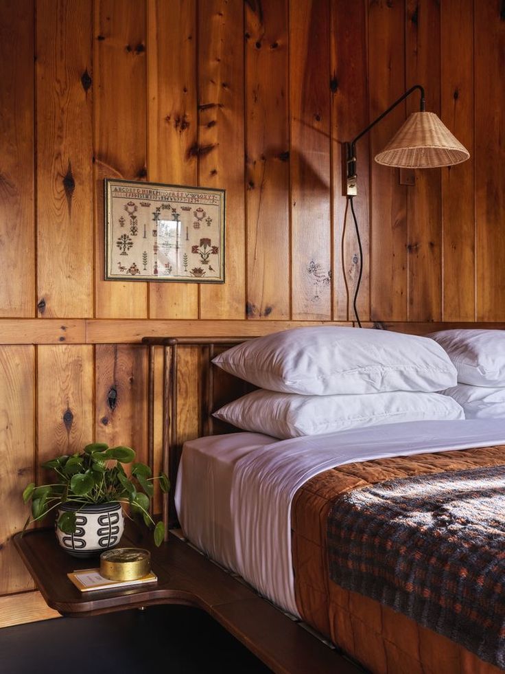 a bedroom with wood paneling and white bedding