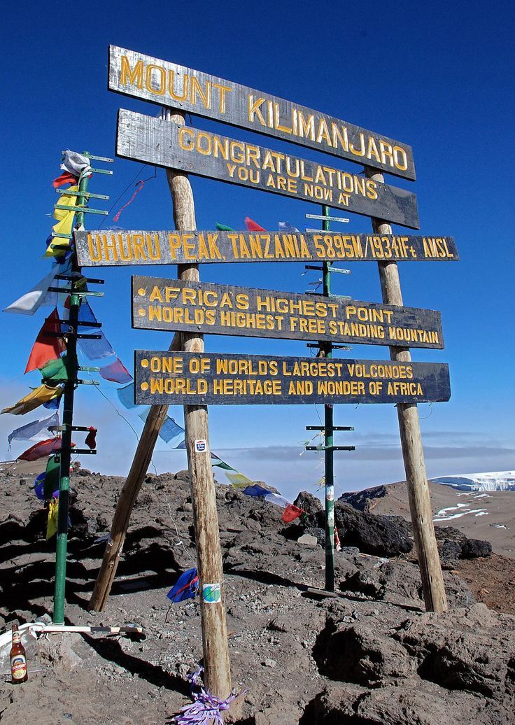 many signs are posted on the top of a mountain